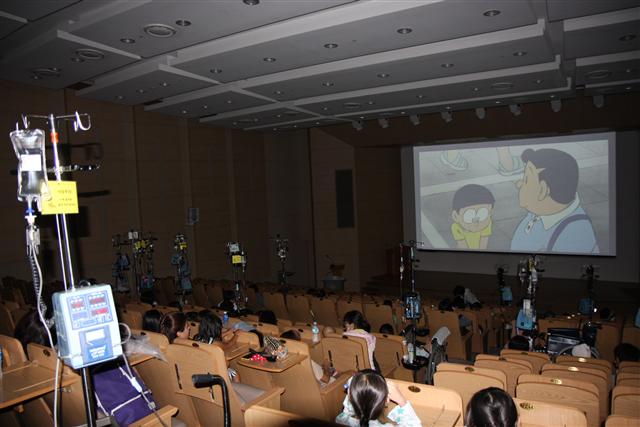 롯데시네마가 지난달 30일 서울대병원 강당에서 개최한 병원 시사회. 만화영화 ‘도라에몽’을 보며 많은 환아들이 육체적 고통을 잊고 모처럼 즐거운 시간을 보냈다.  롯데시네마 제공