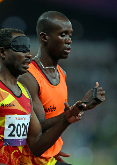 6일 오후(현지시간) 영국 런던 올림픽파크 내 스타디움에서 열린 남자 육상 400ｍ T11 경기에서 시각장애 선수와 가이드가 서로 줄을 잡고 경기를 하고 있다. 연합뉴스