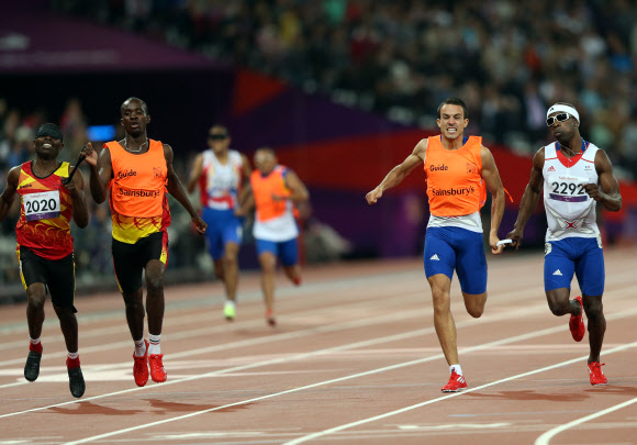 6일 오후(현지시간) 영국 런던 올림픽파크 내 스타디움에서 열린 남자 육상 400ｍ T11 경기에서 시각장애 선수와 가이드가 서로 줄을 잡고 경기를 하고 있다. 연합뉴스