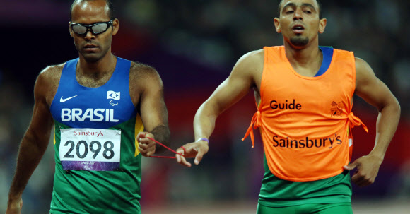 6일 오후(현지시간) 영국 런던 올림픽파크 내 스타디움에서 열린 남자 육상 400ｍ T11 경기에서 시각장애 선수인 실바(브라질.왼쪽)와 가이드가 서로 줄을 잡고 경기를 하고 있다. 연합뉴스