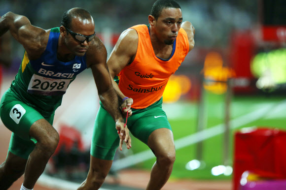 6일 오후(현지시간) 영국 런던 올림픽파크 내 스타디움에서 열린 남자 육상 400ｍ T11 경기에서 시각장애 선수인 실바(브라질.왼쪽)와 가이드가 서로 줄을 잡고 경기를 하고 있다. 연합뉴스