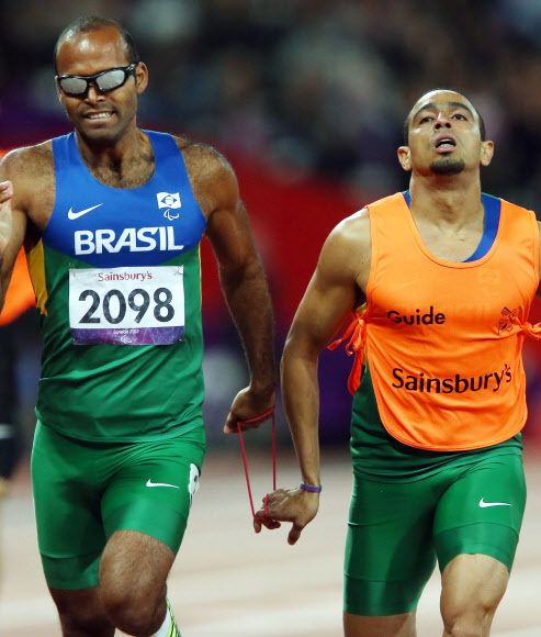 6일 오후(현지시간) 영국 런던 올림픽파크 내 스타디움에서 열린 남자 육상 400ｍ T11 경기에서 시각장애 선수인 실바(브라질.왼쪽)와 가이드가 서로 줄을 잡고 경기를 하고 있다. 연합뉴스