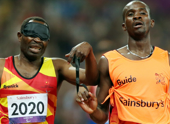 6일 오후(현지시간) 영국 런던 올림픽파크 내 스타디움에서 열린 남자 육상 400ｍ T11 경기에서 시각장애 선수와 가이드가 서로 줄을 잡고 경기를 하고 있다. 연합뉴스