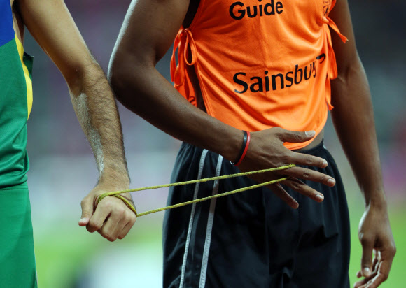 6일 오후(현지시간) 영국 런던 올림픽파크 내 스타디움에서 열린 남자 육상 400ｍ T11 경기에서 시각장애 선수인 실바(브라질.왼쪽)와 가이드가 서로 줄을 잡고 경기를 하고 있다. 연합뉴스