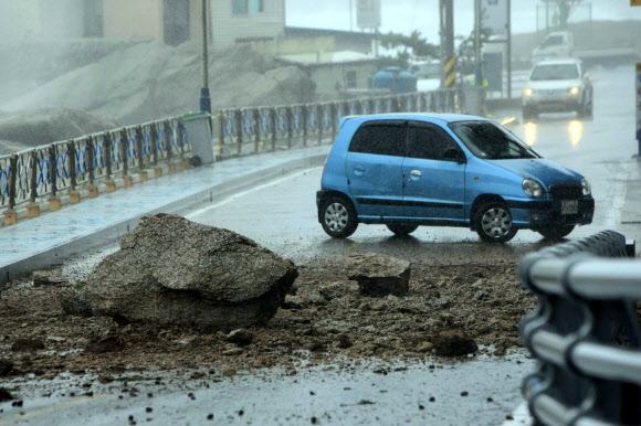 태풍 ‘산바’의 영향으로 영동지방에 많은 비가 내리고 있는 가운데 17일 오후 속초시 영랑동 영금정 해안도로에 낙석이 발생해 차량운행이 통제되고 있다.  연합뉴스