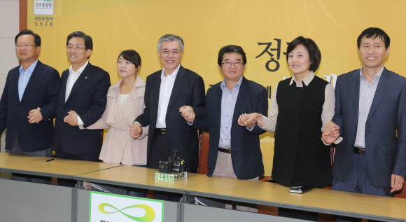 문재인(가운데) 민주통합당 대선후보가 지난 20일 당사에서 열린 대선기획단인 ‘담쟁이 기획단’ 회의에서 위원들과 손을 잡고 있다.  이호정기자 hojeong@seoul.co.kr