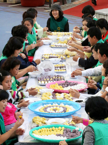 송파구가 추석을 맞아 26일 오전 서울 송파구 석촌호수 서호 서울놀이마당에서 다문화가정 결혼이민여성들과 함께 사랑의 송편 나누기 행사를 하고 있다.  연합뉴스