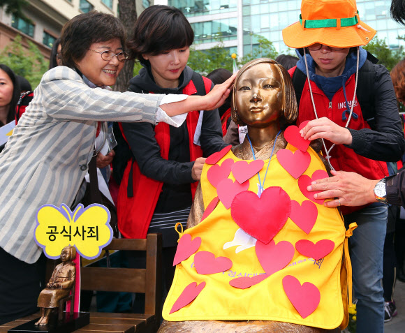 10일 오후 서울 종로구 주한일본대사관 앞에서 열린 일본군 위안부 문제해결 촉구 수요집회에서 참가자들이 하트 모양의 종이를 소녀상에 붙이는 퍼포먼스를 선보이고 있다.  연합뉴스