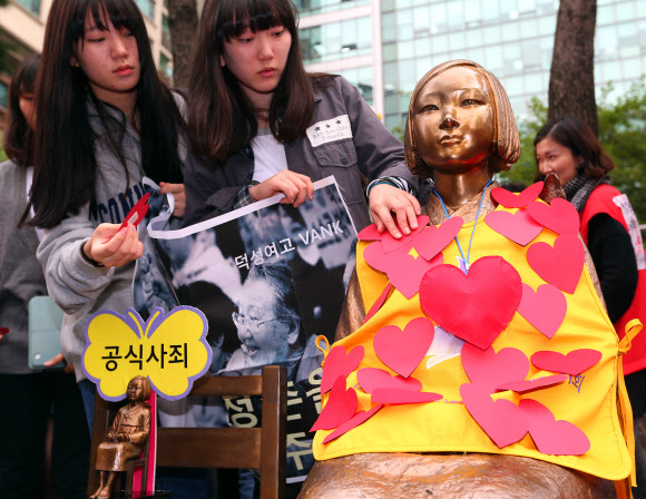 10일 오후 서울 종로구 주한일본대사관 앞에서 열린 일본군 위안부 문제해결 촉구 수요집회에서 참가자들이 하트 모양의 종이를 소녀상에 붙이는 퍼포먼스를 선보이고 있다.  연합뉴스