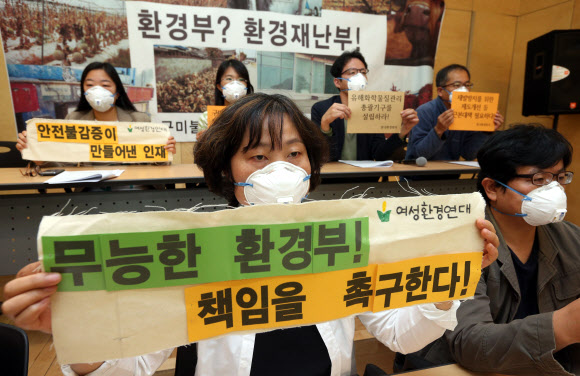 11일 서울 중구 정동 환경재단 레이첼카슨홀에서 한국환경회의 주최로 열린 구미 불산가스 누출사건 기자회견에서 참석자들이 항의의 표시로 마스크를 쓴 채 환경부를 규탄하는 손팻말을 펼쳐보이고 있다. 연합뉴스