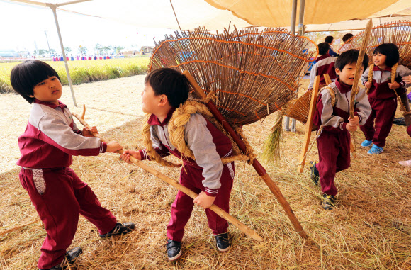 전북 김제시 부량면 벽골제 일대에서 열리는 김제지평선축제장에서 꼬마들이 12일 물건을 옮기는 지게를 체험하고 있다. 국내 최대의 농경체험 지평선축제는 14일까지 계속된다.  연합뉴스
