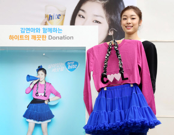 하이트진로는 지난 13일 부산 해운대구 롯데백화점 센텀점에서 자사 맥주 브랜드 하이트의 모델인 김연아 선수와 함께 ‘깨끗한 기부’ 자선바자회를 개최, 김연아 선수가 하이트맥주 광고 촬영 당시 착용했던 의상을 소개하고 있다. 연합뉴스