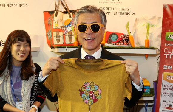 선글라스에 티셔츠  문재인 민주통합당 대선 후보가 16일 서울 코엑스에서 열린 ‘제11회 세계한상대회’를 찾아 한 기업체가 만든 선글라스를 쓰고 티셔츠를 들어 보이고 있다. 연합뉴스