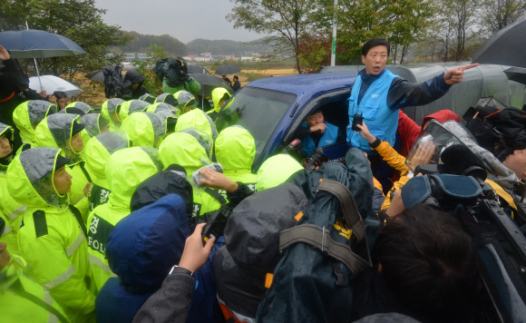 국내 탈북자 단체들이 22일 경기 파주 임진각에서 대북 전단을 살포하려다 경찰의 통제로 무산되자 박상학(차에 올라탄 사람) 자유북한운동연합 대표가 인근 자유로에서 경찰에 둘러싸인 채 거세게 항의하고 있다.  파주 박지환기자 popocar@seoul.co.kr 
