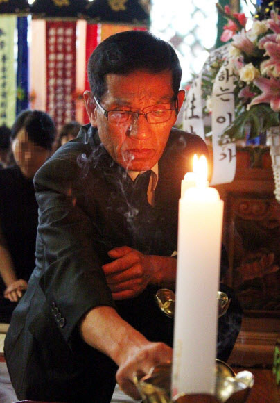 ‘울산 자매 살인사건’ 피해자의 아버지 박종환씨가 지난달 6일 울산 중구 백양사에서 열린 두 딸의 49재에서 향을 피우고 있다.  연합뉴스