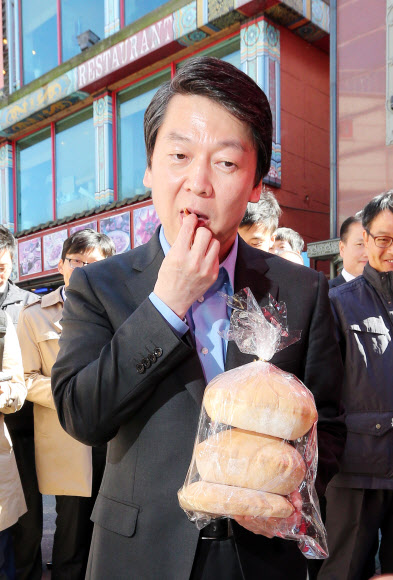 무소속 안철수 대선후보가 23일 오전 인천 중구 북성동 차이나타운을 방문, 상인들과 인사를 나누며 공갈빵을 맛보고 있다. 연합뉴스