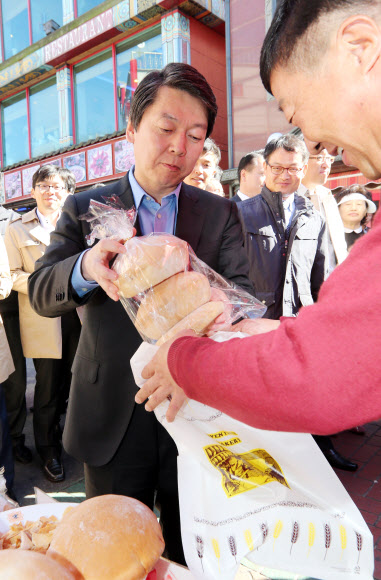 무소속 안철수 대선후보가 23일 오전 인천 중구 북성동 차이나타운을 방문, 점식식사를 마친 뒤 한 상점에 들러 공갈빵을 사고 있다. 연합뉴스