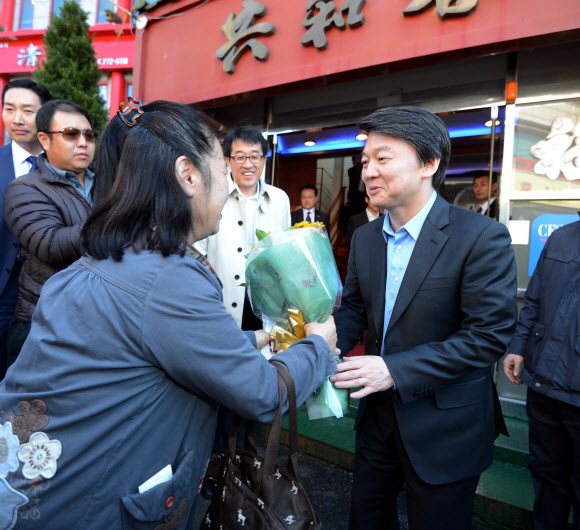 무소속 안철수 대선후보가 23일 인천 북성동 차이나타운을 방문, 이 지역 토박이인 김순혜씨로부터 편지와 꽃다발을 선물받고 있다. 연합뉴스