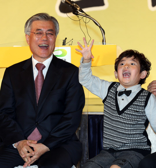 민주통합당 문재인 대선후보가 25일 오전 대구 제이스 호텔에서 열린 대구시당-경북도당 선대위 출범식에서 엄마를 따라온 한 아이가 악수한 손을 치켜들자 크게 웃고 있다. 연합뉴스