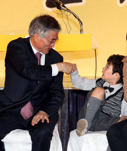 민주통합당 문재인 대선후보가 25일 오전 대구 제이스 호텔에서 열린 대구시당-경북도당 선대위 출범식에서 엄마를 따라온 한 아이와 악수하고 있다. 연합뉴스