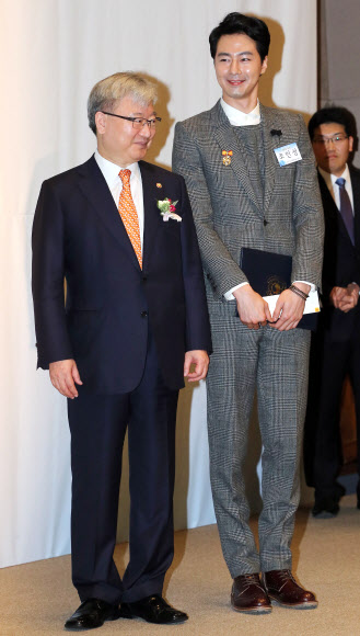 배우 조인성이 30일 오전 서울 중구 프레스센터에서 열린 제49회 저축의 날 기념식에서 금융위원회로부터 대통령 표창을 받고 금융위원회 김석동 위원장과 기념촬영을 하고 있다. 연합뉴스