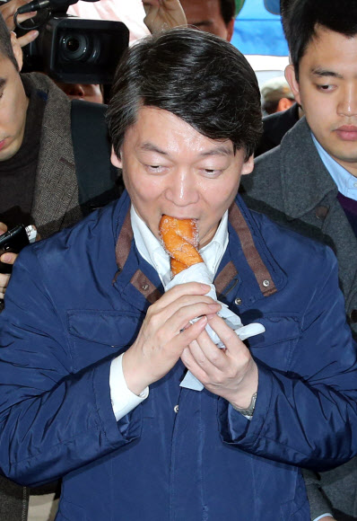 무소속 안철수 대선후보가 4일 오전 전북 익산시 솜리장을 방문, 한 상인이 건넨 꽈배기를 맛보고 있다.  연합뉴스