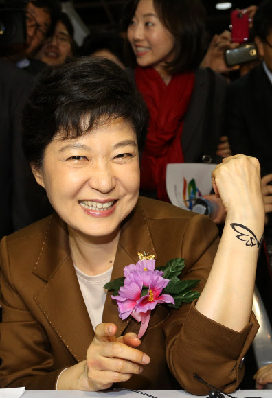 새누리당 박근혜 대선후보가 5일 오후 서울 서초구 양재동 aT센터에서 열린 한국미용페스티벌에 참석, 건국대학교 미용학과 부스를 방문해 손목에 새긴 날개모양의 타투를 들어보이고 있다. 연합뉴스