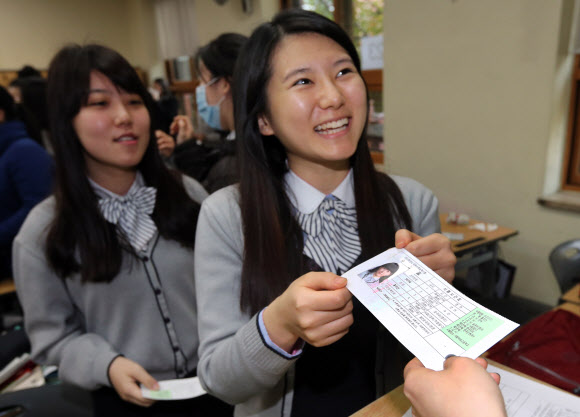 수능시험을 하루 앞둔 7일 오전 서울 명동 계성여자고등학교 학생들이 수험표를 받고 있다. 연합뉴스