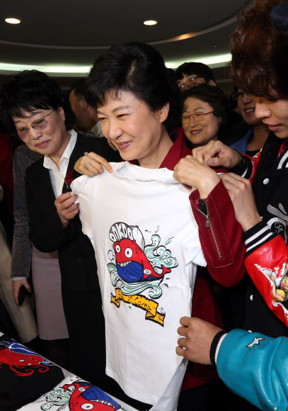 새누리당 박근혜 대선후보가 7일 오후 서울 중구 프레스센터에서 열린 여성유권자연맹 해피바이러스 콘서트 행사장 입구에서 독도 컨셉으로 디자인 된 티셔츠를 구경하고 있다. 연합뉴스