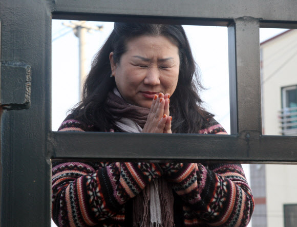 2013학년도 대학수학능력시험이 치러지는 8일 오전 제주여자고등학교 정문 앞에서 한 학부모가 기도를 하고 있다.  연합뉴스