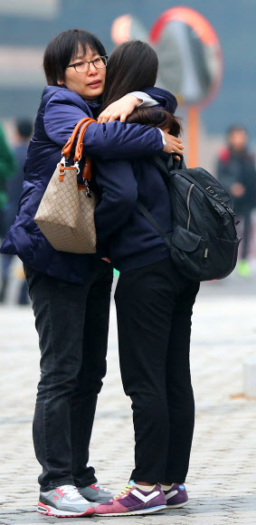 2013학년도 대학수학능력시험이 시행된 8일 오전 서울 중구 명동 계성여자고등학교 앞에서 한 수험생이 어머니와 포옹을 하고 있다.  연합뉴스