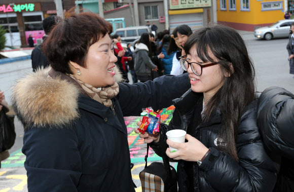 8일 강원 강릉시 강일여고의 대입 수능시험장 앞에서 한 학교의 선생님이 시험을 보는 제자를 따뜻하게 안아주며 격려하고 있다.  연합뉴스