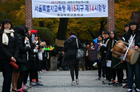 2013학년도 대학수학능력시험이 시행된 8일 오전 서울 중구 명동 계성여자고등학교 앞에서 한 수험생이 후배들의 함성을 받으며 수험장으로 향하고 있다. 연합뉴스