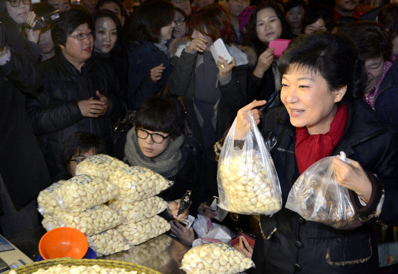 새누리당 박근혜 대선후보가 13일 오전 충남 천안시 서북구 신당동 농수산물시장을 방문 깐마늘과 생강을 사고 있다.  연합뉴스