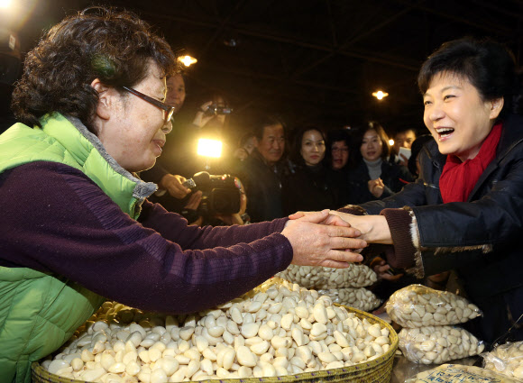 새누리당 박근혜 대선후보가 13일 오전 충남 천안시 서북구 신당동 농수산물시장을 방문 깐마늘과 생강을 사고 있다.  연합뉴스