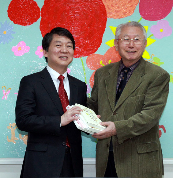 무소속 안철수 대선후보가 13일 오후 서울 종로구 신교동 푸르메재단을 방문, 재단이사장인 김성수 대한성공회 주교와 면담하기에 앞서 책을 선물받고 있다.  연합뉴스