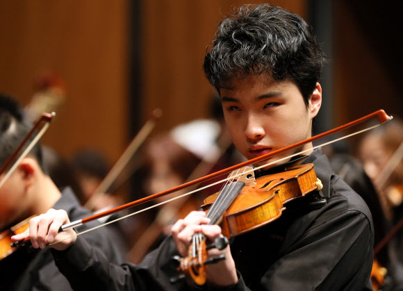 시각장애 특수학교인 인천혜광학교의 한 학생이 14일 오전 인천시 남동구 인천종합문화예술회관에서 열리는 연주회를 앞두고 바이올린을 켜며 예행연습을 하고 있다. 연합뉴스