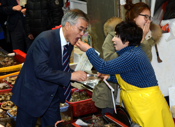 민주통합당 문재인 대선후보가 14일 오후 부산 남포동 자갈치 시장을 방문, 상인이 썰어 준 회를 맛보고 있다. 연합뉴스