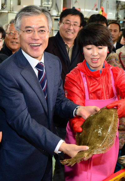 민주통합당 문재인 대선후보가 14일 오후 부산 남포동 자갈치 시장을 방문, 직접 구입한 광어를 들어보이며 밝은 표정을 짓고 있다. 연합뉴스