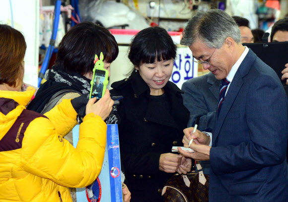 민주통합당 문재인 대선후보가 14일 오후 부산 남포동 자갈치 시장을 방문, 장을 보러 나온 부산 시민들에게 사인을 해주고 있다.  연합뉴스