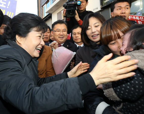 새누리당 박근혜 대선후보가 14일 오후 충북 충주시 성서동 차없는 거리를 걸으며 우는 아기를 달래고 있다. 연합뉴스