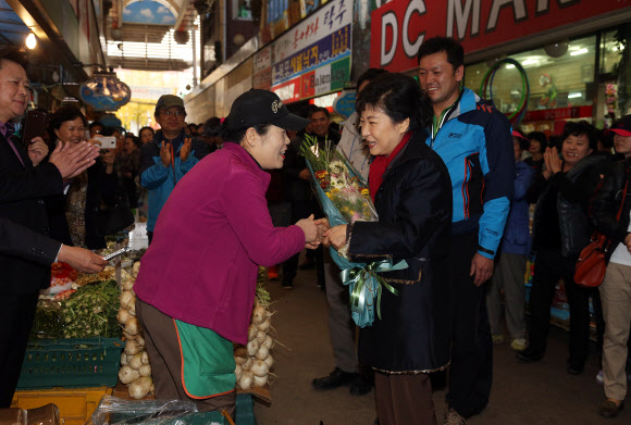 새누리당 박근혜 대선후보가 16일 오후 경남 창원시 성산구 가음동 가음정시장을 방문, 채소가게에 들러 가게주인에게 꽃다발을 받고 있다.  연합뉴스 