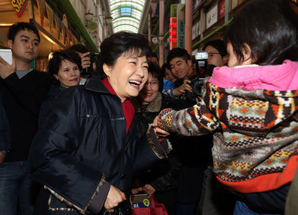 새누리당 박근혜 대선후보가 16일 오후 경남 창원시 성산구 가음동 가음정시장을 방문, 한 아기의 손을 잡으며 인사하고 있다.  연합뉴스