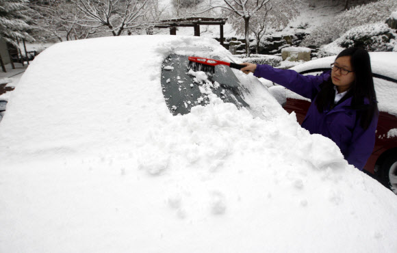 19일 오전 첫눈이 내린 강원 춘천시내에서 학생이 눈을 치우고 있다. 춘천의 첫눈은 지난해보다 3일 빠르다고 기상청은 밝혔다. 연합뉴스