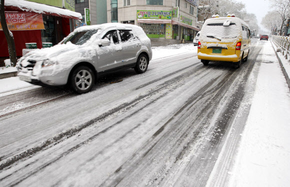 19일 오전 첫눈이 내린 강원 춘천시내에서 차량이 힘겹게 언덕길을 오르고 있다. 춘천의 첫눈은 지난해보다 3일 빠르다고 기상청은 밝혔다. 연합뉴스