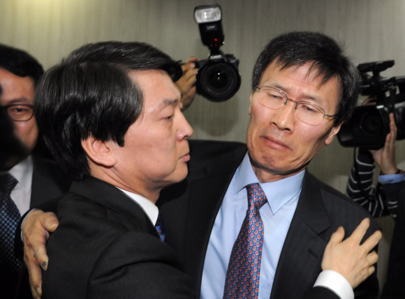 안철수 무소속 대선 후보가 23일 서울 종로구 공평동 선거캠프에서 후보 사퇴 의사를 밝힌 뒤 당사를 떠나며 윤영관(오른쪽) 국민정책본부장과 침통한 표정으로 포옹하고 있다. 박지환기자 popocar@seoul.co.kr 