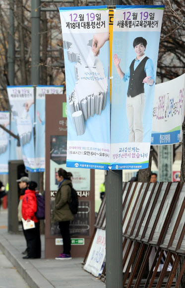 서울특별시선거관리위원회 직원들이 25일 오전 서울 종로구 세종로에서 18대 대통령선거와 시교육감재선거 참여 유도를 위한 가로등 배너를 설치하고 있다.  연합뉴스
