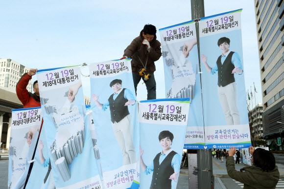 서울특별시선거관리위원회 직원들이 25일 오전 서울 종로구 세종로에서 18대 대통령선거와 시교육감재선거 참여 유도를 위한 가로등 배너를 설치하고 있다.  연합뉴스