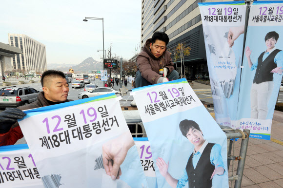 서울특별시선거관리위원회 직원들이 25일 오전 서울 종로구 세종로에서 18대 대통령선거와 시교육감재선거 참여 유도를 위한 가로등 배너를 설치하고 있다.  연합뉴스