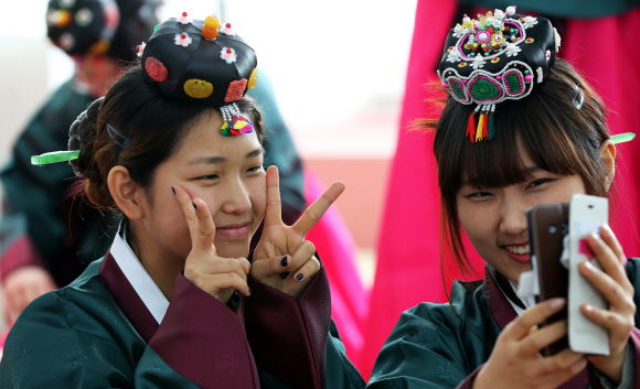 26일 오전 경기도 양평군 옥천면 양근향교에서 수능을 마친 양평고등학교 고3 여학생들이 성년식을 치르기 위해 한복을 착용한 후 휴대폰으로 자신들의 모습을 담으며 환하게 웃고 있다. 연합뉴스